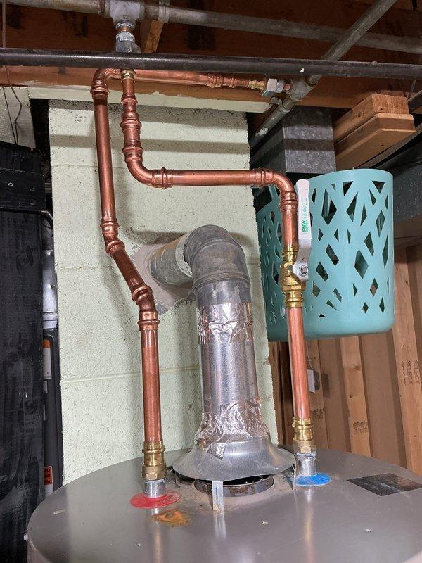 Coordinated with municipal water department to shut off water supply at the street main. Installed new shut-off valves before and after the water meter to establish functional main water control for the residence. Repiped water lines above the water heater using copper pipe and installed new dedicated shut-off valve for water heater isolation. Replaced supply valves for downstairs bathroom fixtures and reconnected to existing CPVC distribution lines. Replaced supply valves for upstairs bathroom fixtures with new quarter-turn ball valves. Cut access opening in ceiling to reach upstairs cold water line valve location and installed access panel for future maintenance. All valve replacements utilized quarter-turn ball valve technology for improved reliability and ease of operation. All new water supply piping installed with Type L copper pipe and brass fittings to ensure code compliance and system longevity.