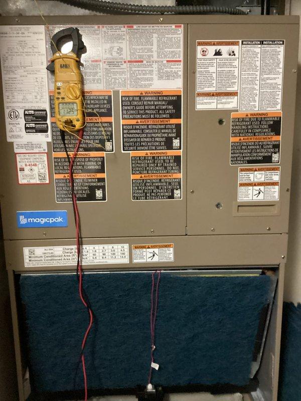 Completed heating tune-up service on MagicPak HVAC unit. Replaced thermostat batteries, installed new air filter, and performed system inspection with multimeter testing to verify proper electrical operation and heating functionality.