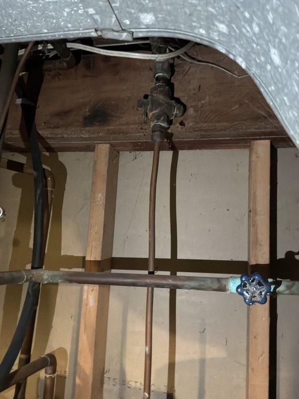 Responded to service call for non-operational water heater. Upon arrival, conducted visual inspection of Richmond brand residential water heater unit located in basement utility area. Assessed existing plumbing connections including copper supply lines, shut-off valve assembly with blue handle, and associated piping infrastructure. Documented current condition of unit, surrounding mechanical systems, and exposed ceiling structure where plumbing connections are routed. Provided estimate for water heater replacement or repair based on diagnostic findings and equipment condition assessment.