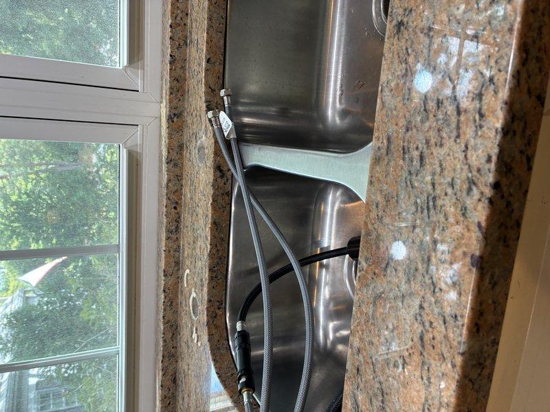 Disconnected kitchen sink, garbage disposal, and stove in preparation for new countertop installation. All plumbing connections were safely isolated and capped to prevent water damage during the renovation work.
