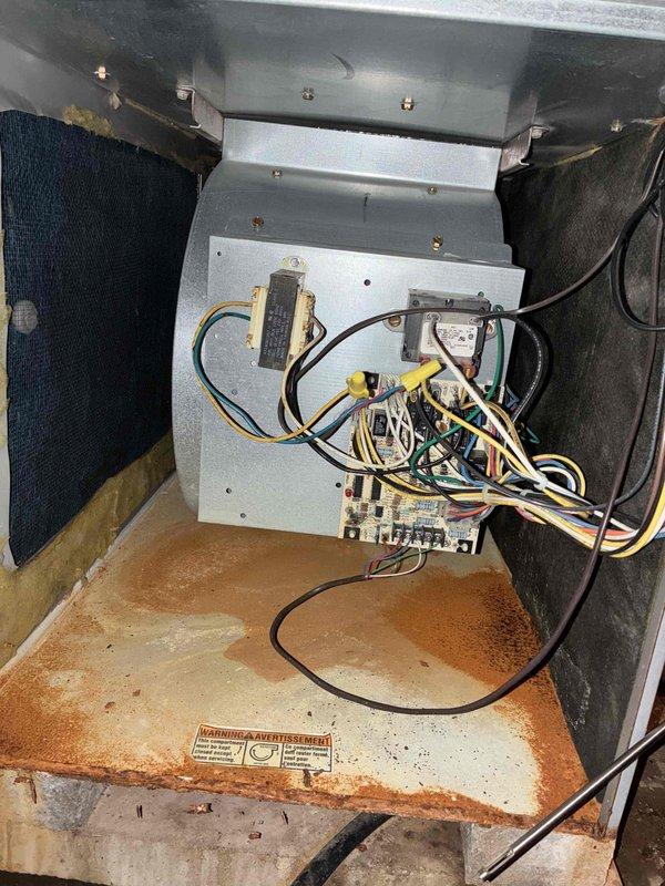 # HVAC No Heat Service Call - 10+ Year Old Unit

Responded to no heat complaint on aging HVAC system. Upon arrival, conducted diagnostic inspection of unit interior and control systems. Accessed main control compartment and evaluated primary and secondary control boards for functionality. Inspected electrical connections, relay terminals, and capacitor components. Observed significant rust deterioration on unit base and interior housing, indicating extended service life and moisture exposure history. Examined wiring harnesses with multiple conductor connections to control board terminal blocks. Verified circuit board components including resistors, capacitors, and relay switches for proper operation. Documented existing condition of control boards showing populated electronic components and connection points. Assessed overall system condition noting age-related wear patterns consistent with 10+ year old equipment. Photographed control board assembly and interior compartment for service