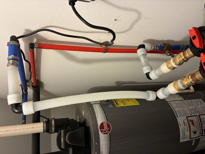 Installed a complete water softening system with associated plumbing connections, including blue filter housing with white PVC supply lines, brass shut-off valves, and proper integration with existing hot water distribution system. Repaired and serviced exterior hose bibs to restore proper function and prevent leaks.