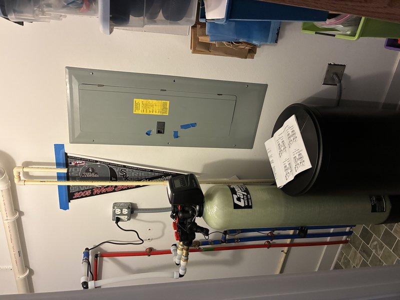 Installed a complete water softening system with associated plumbing connections, including blue filter housing with white PVC supply lines, brass shut-off valves, and proper integration with existing hot water distribution system. Repaired and serviced exterior hose bibs to restore proper function and prevent leaks.