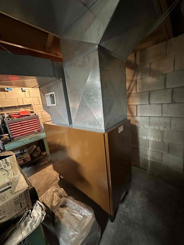 Conducted on-site assessment for residential HVAC system conversion from oil-fired furnace to gas-fired heating equipment. Evaluated existing furnace installation in basement mechanical room, documented current ductwork configuration including pyramid-style plenum system, and assessed exterior condensing unit condition. Provided comprehensive estimate for complete system replacement, noting that natural gas service line installation by utility-approved contractor is prerequisite before furnace conversion can proceed.