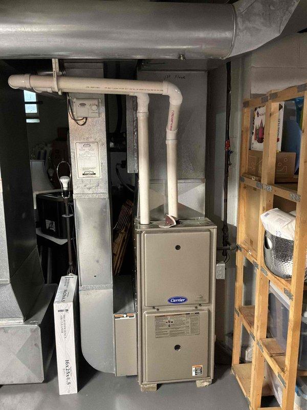 Provided comprehensive estimate for complete HVAC system replacement including a natural gas furnace originally installed in 2013 that has required repeated costly repairs, and an air conditioning condenser unit from 2003 with confirmed refrigerant leak. The existing furnace is located in the basement mechanical room with current venting configuration through PVC piping, while the outdoor condenser unit sits on a concrete pad against the home's exterior siding. Recommended full system replacement to address ongoing reliability issues and eliminate continued repair expenses on aging equipment that has exceeded its serviceable lifespan.