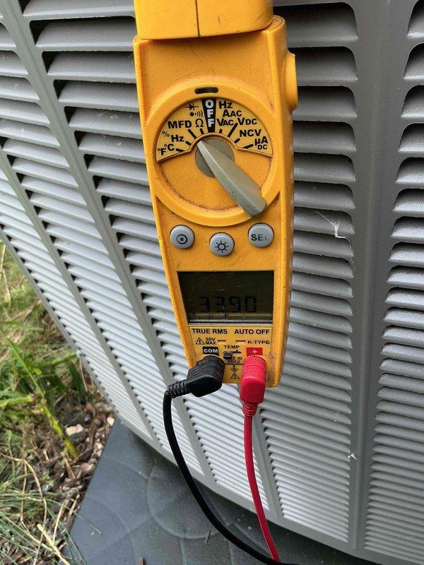 Completed air conditioning tune-up and system evaluation on outdoor condensing unit. Performed electrical diagnostics using digital multimeter to verify proper voltage and amperage readings. Cleared excessive vegetation growth that had accumulated around and through the unit's fan grille and louvered panels, which was restricting airflow and potentially impacting system efficiency. Discussed duct cleaning services with customer as requested.