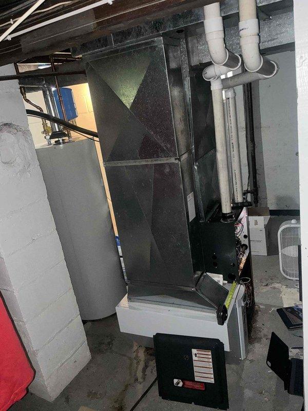 Responded to emergency service call for 32-year-old residential air conditioning system experiencing operational issues. Conducted comprehensive system evaluation and provided detailed replacement estimate for aging HVAC equipment installed in basement mechanical room. Assessment included existing furnace/air handler unit with associated PVC drainage and ventilation piping, condensate management system, and connected components showing signs of age-related deterioration requiring full system replacement recommendation.