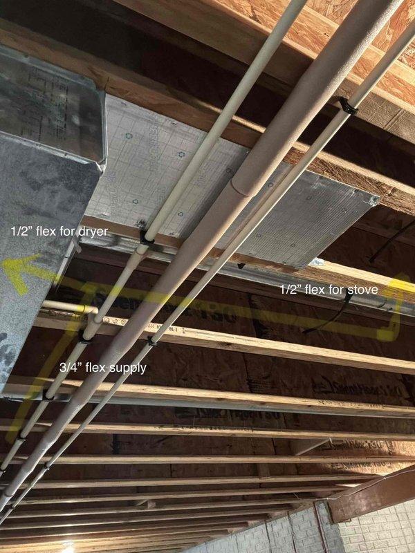 Conducted site assessment for gas line extension from basement to second floor. Documented existing gas infrastructure including current 1/2" flex lines serving dryer and stove, along with 3/4" supply line running through basement ceiling joists. Evaluated routing path through floor framing system and identified access points for vertical run to second floor. Photographed existing utility layout including HVAC ductwork, structural supports, and water heater location to determine optimal pipe routing while maintaining clearances from other building systems.
