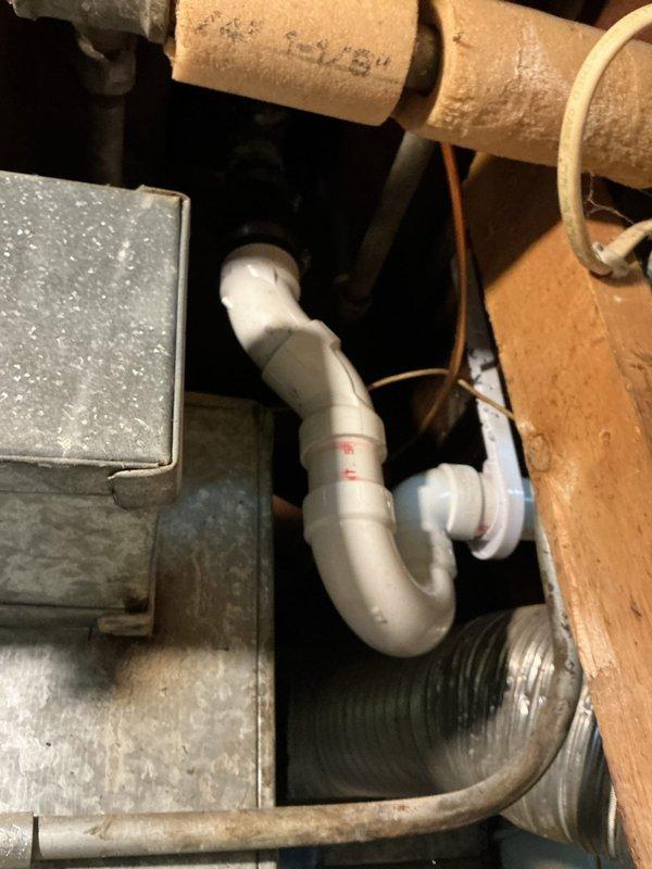 Completed assessment and sold repiping repair for residential plumbing system showing significant deterioration. Inspected corroded galvanized piping with extensive rust buildup on horizontal runs and vertical drops, along with aging P-trap assembly beneath fixture. Documented deteriorated metal pipe infrastructure in utility area with compromised fittings and joints exhibiting orange-brown corrosion throughout. Recommended complete repiping solution to address failing galvanized lines and prevent future leaks or water quality issues.