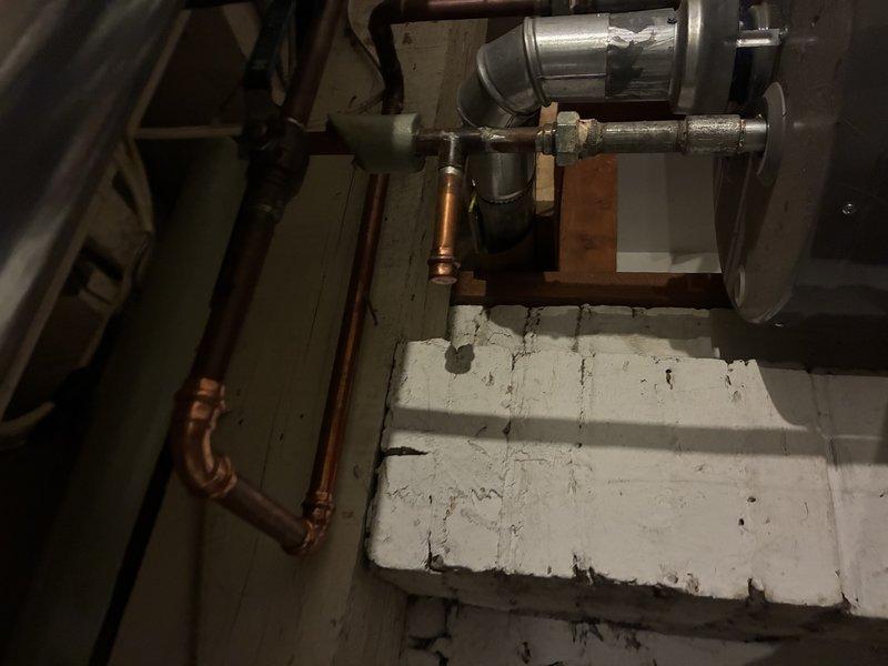 Responded to service call for temperature and pressure relief valve actively discharging water on tanked water heater system. Upon arrival, inspected water heater installation in basement utility area and confirmed T&P valve was continuously releasing water, indicating either excessive system pressure, elevated water temperature, or valve failure. Evaluated overall condition of copper supply piping, connections, and mounting configuration. Diagnosed cause of discharge issue and assessed water heater operation including temperature settings and pressure conditions. Replaced faulty T&P relief valve with new code-compliant unit, ensuring proper installation torque and orientation for safe discharge routing. Tested system operation under normal conditions to verify proper valve seating and confirmed no further water discharge occurring. System restored to safe operating condition with proper pressure relief protection in place.