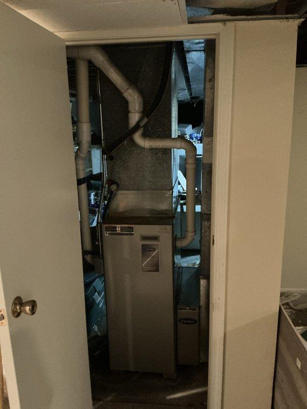 Responded to emergency furnace service call and conducted thorough assessment of existing HVAC system located in utility closet. Upon inspection, identified failed heat exchanger requiring immediate replacement due to safety concerns. Documented existing beige furnace unit with connected gray PVC ductwork and observed aged plumbing infrastructure with visible corrosion on copper piping and metal components. Provided comprehensive estimate for complete furnace replacement system to address heat exchanger failure and ensure safe, efficient operation of heating system.