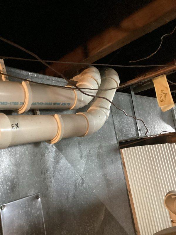 Completed full furnace installation in basement mechanical room with all required permits obtained. New gray metal furnace unit installed on concrete pad with proper clearances, including connection of black flexible ducts, refrigerant lines with service ports, and white PVC venting system secured to floor joists with appropriate hangers. Licensed electrician completed all electrical connections and wiring in accordance with local codes. System tested and verified operational upon completion.