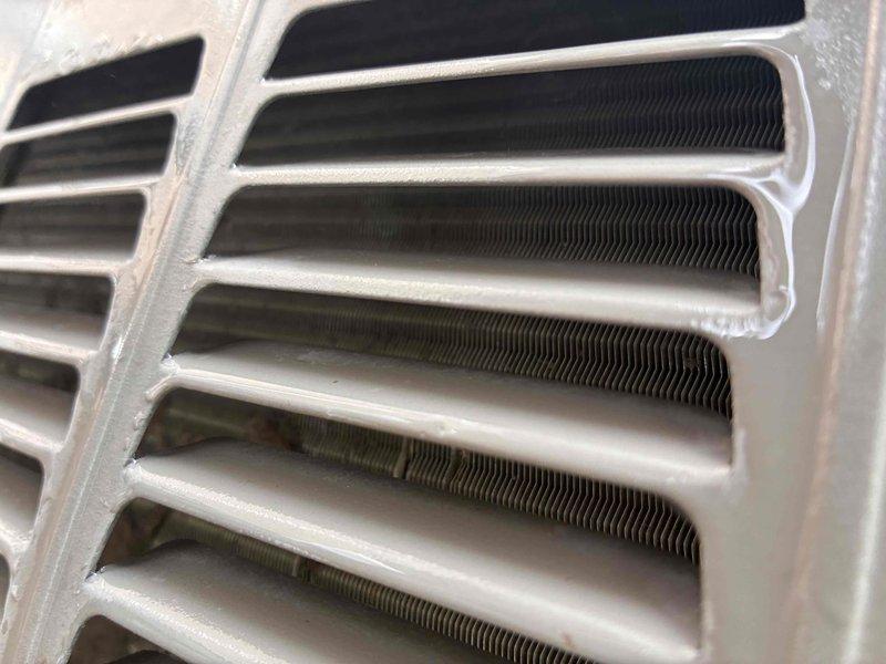 Completed comprehensive tune-up service on residential split HVAC system, including furnace and air conditioning condenser unit. Performed detailed inspection of heat exchanger assembly, verifying fin integrity and proper airflow through corrugated aluminum fins. Inspected outdoor condenser unit mounted on concrete pad, checked fan operation, examined louvered panels for proper ventilation, and verified electrical connections at disconnect box and conduit routing along exterior wall. All components found operating within normal parameters with no immediate service needs identified.