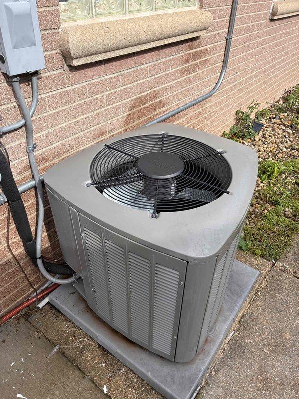 Completed comprehensive tune-up service on residential split HVAC system, including furnace and air conditioning condenser unit. Performed detailed inspection of heat exchanger assembly, verifying fin integrity and proper airflow through corrugated aluminum fins. Inspected outdoor condenser unit mounted on concrete pad, checked fan operation, examined louvered panels for proper ventilation, and verified electrical connections at disconnect box and conduit routing along exterior wall. All components found operating within normal parameters with no immediate service needs identified.