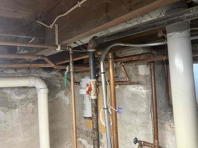 Conducted boiler replacement estimate for existing unit currently operational but deteriorating and unlikely to survive upcoming heating season. Assessed basement installation area with exposed plumbing infrastructure including copper lines, PVC venting, and existing gas piping. Recommended high-efficiency boiler system without indirect water heater tank based on current configuration and customer requirements.