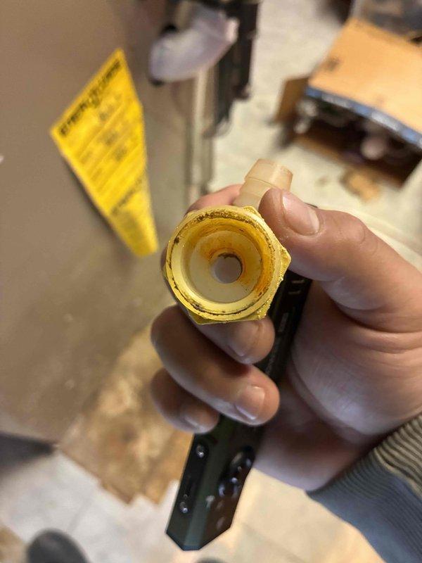 Responded to service call for reported leak at furnace. Upon inspection, identified leaking gas line connection at furnace inlet. Removed and inspected brass hexagonal pipe fitting, which showed significant wear, oxidation, and deteriorated thread sealant. Replaced faulty fitting with new brass connector, applied appropriate thread sealant, and torqued to manufacturer specifications. Performed leak test using soap solution to verify repair integrity. Placed protective insulation material in work area during repair. System tested and confirmed no further leaks present at furnace connections.