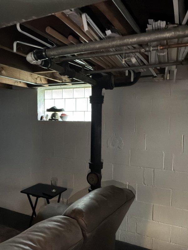 Conducted comprehensive whole-house repipe estimate for residential property requiring replacement of existing iron supply piping with copper and outdated drain lines with PVC. Assessed basement utility area with exposed ceiling joists, documenting current plumbing infrastructure including existing metal pipes, HVAC ductwork, and structural layout to determine scope of work for complete piping system replacement.