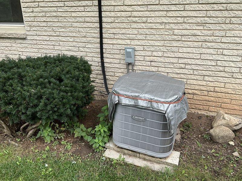 Completed estimate for attic-mounted air handler replacement serving residential HVAC system. Evaluated existing functional but aging unit located in attic space with exposed wooden framework, assessed current ductwork configuration including black flexible ducts, and inspected outdoor Carrier condenser unit mounted on concrete pad against exterior brick wall. Provided replacement recommendations and pricing options for complete air handler system upgrade.