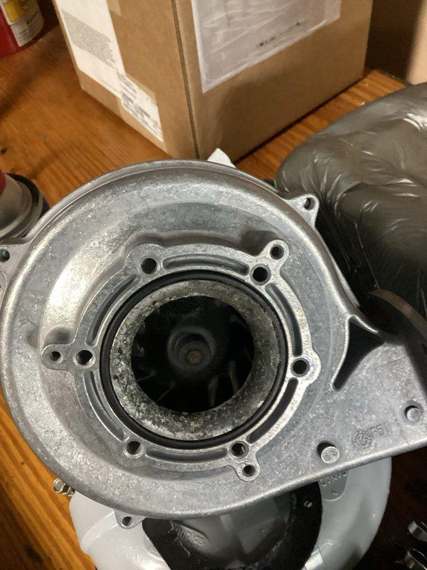 Responded to service call and diagnosed failed blower assembly on NTI Vmax high-efficiency boiler unit. Removed defective centrifugal blower housing with damaged impeller wheel and replaced with new OEM assembly. Verified proper mounting, tested unit operation, and confirmed system returned to normal heating function.