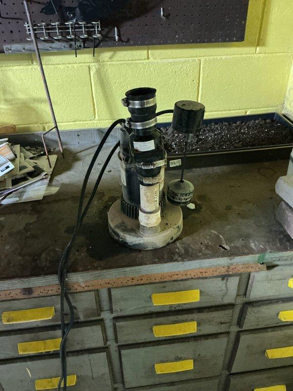 Completed estimate for sump pump replacement with battery backup system installation. Assessed existing sump pump unit showing signs of wear and operational degradation, documented current setup including pump housing, discharge piping configuration, and sump basin condition. Evaluated workspace accessibility and determined requirements for upgraded system with integrated battery backup to ensure continuous operation during power outages. Photographed existing equipment and basin opening to document pre-replacement conditions and provide specifications for replacement unit sizing and installation planning.