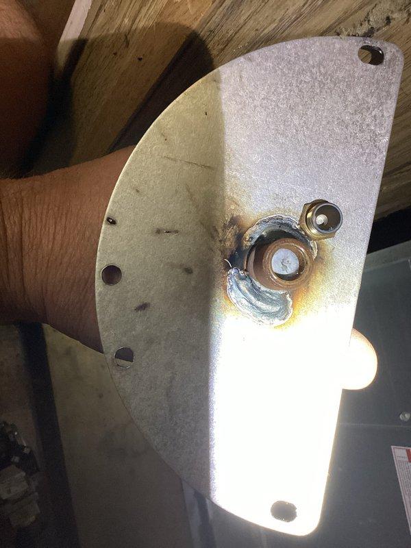 Responded to no heat call and diagnosed failed inducer motor assembly. Motor bearing showed significant heat damage and discoloration, causing complete failure and preventing furnace operation. Removed damaged inducer motor housing, documented extent of thermal damage to mounting bracket and bearing assembly, and prepared unit for replacement part installation to restore heating functionality.