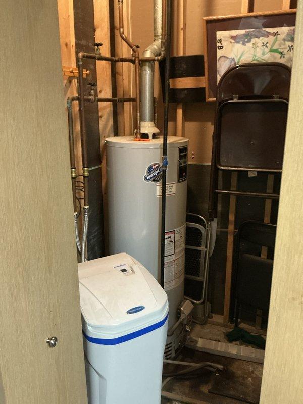 Completed water heater replacement estimate for residential property. Assessed existing water heater installation in unfinished basement utility area, including evaluation of current copper supply piping, shut-off valves, venting system, and clearances around unit. Documented existing conditions with photographs showing water heater positioned adjacent to water softener and HVAC equipment. Provided customer with replacement recommendations and pricing options for new water heater installation.