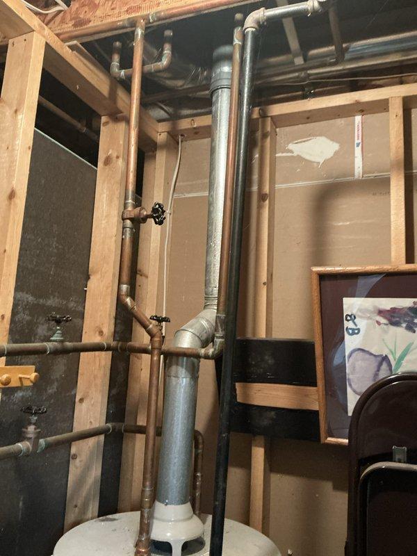 Completed water heater replacement estimate for residential property. Assessed existing water heater installation in unfinished basement utility area, including evaluation of current copper supply piping, shut-off valves, venting system, and clearances around unit. Documented existing conditions with photographs showing water heater positioned adjacent to water softener and HVAC equipment. Provided customer with replacement recommendations and pricing options for new water heater installation.