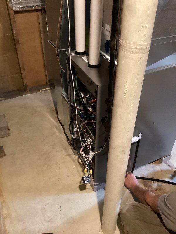 Completed full furnace installation in basement utility space with all necessary permits obtained and electrical work coordinated with licensed electrician. New HVAC unit installed with proper PVC venting system, electrical connections secured and tested, and all components mounted to code specifications in unfinished basement area with concrete block walls and exposed floor joists.