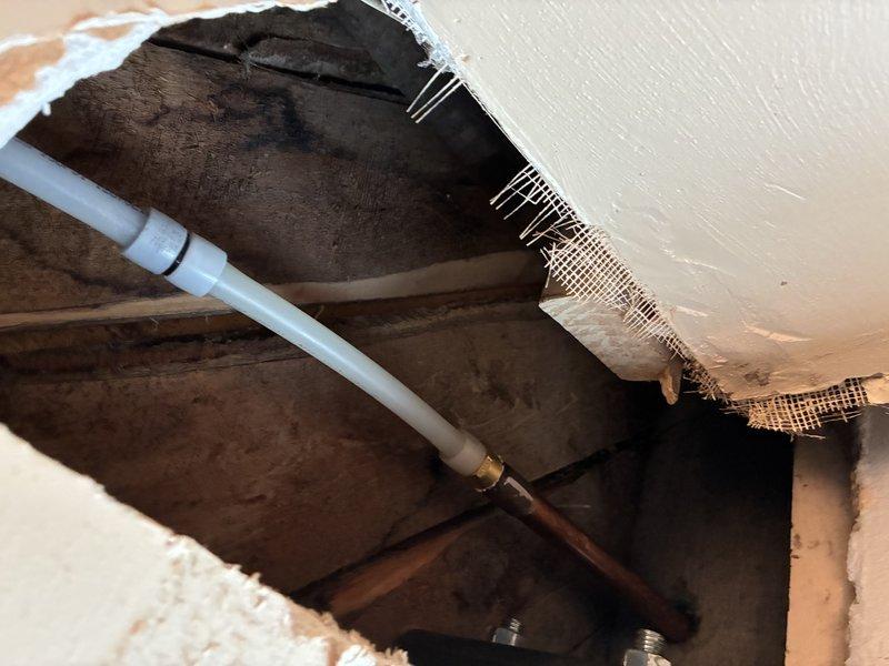 Responded to emergency call for burst pipe in basement. Upon arrival, performed diagnostic inspection and located compromised copper supply line behind damaged drywall section. Extensive water damage and staining evident throughout affected cavity area, indicating prolonged leak prior to pipe failure. Assessed structural framing and plumbing configuration, documented damage with photos, and provided customer with repair recommendations including pipe replacement and restoration of water-damaged surfaces.