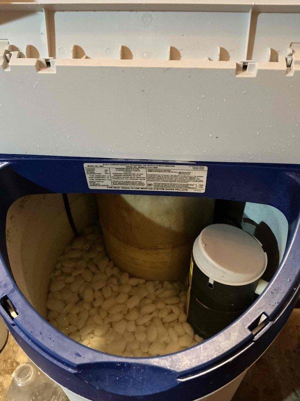 Diagnosed water softener system experiencing regeneration failure and identified damaged electrical wiring to the brine tank assembly. Inspected control valve mechanism, examined mineral buildup on PVC piping and connections, and assessed overall system condition to determine repair requirements.