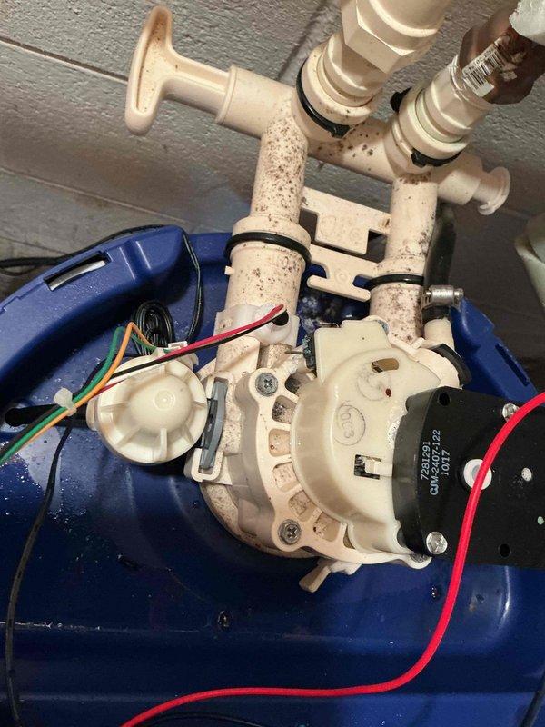 Diagnosed water softener system experiencing regeneration failure and identified damaged electrical wiring to the brine tank assembly. Inspected control valve mechanism, examined mineral buildup on PVC piping and connections, and assessed overall system condition to determine repair requirements.
