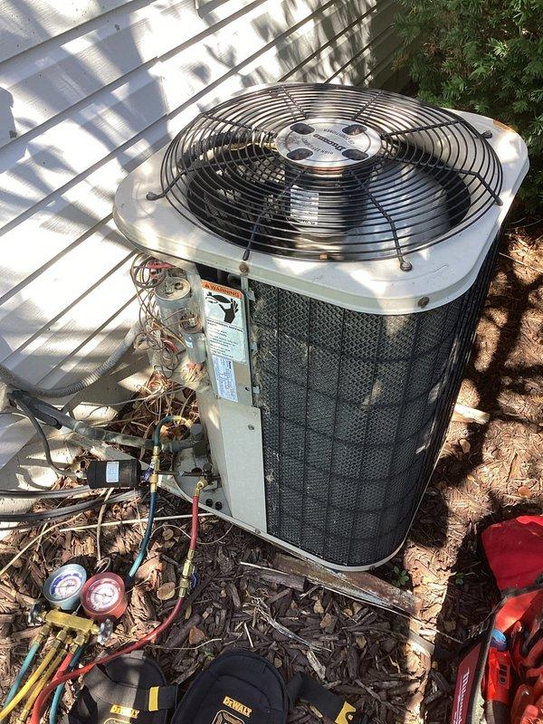 Performed pre-replacement inspection of 20-year-old furnace and air conditioning system. Evaluated AC condenser unit experiencing coil icing issues during operation. Connected manifold gauges to measure refrigerant pressures and assess system performance. Documented equipment condition with photographs showing outdoor condenser unit with service panel open, internal components including copper refrigerant lines, electrical connections, and mechanical assemblies. Inspection findings will support upcoming replacement estimate for both furnace and AC system.