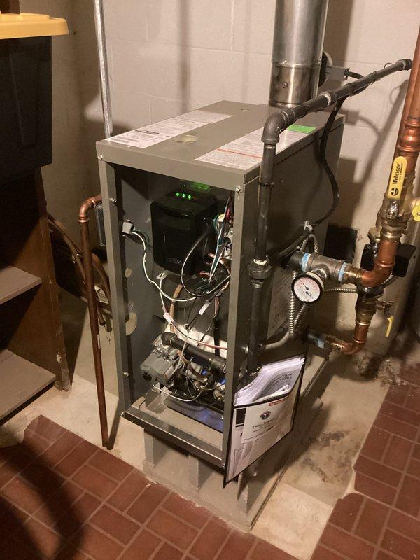 Responded to no-heat service call for boiler system producing buzzing sound and failing to operate. Upon arrival, performed diagnostic inspection of heating unit with front access panel opened to examine internal components. Identified control board issue preventing proper ignition sequence. Inspected electrical connections, wiring harness, and circuitry including green indicator lights on control panel. Evaluated gas valve operation, pressure switches, and safety interlocks. Tested system operation and restored heat to residence.