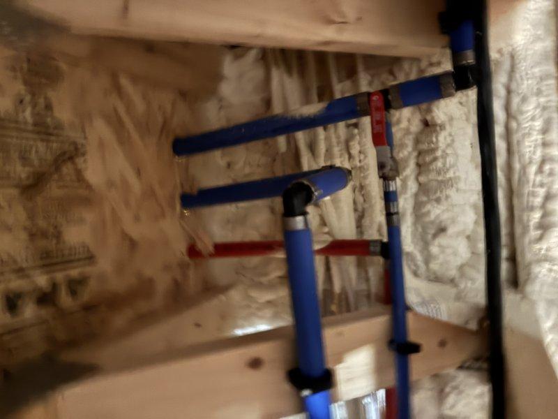 Installed and routed new water supply lines from the tanked water heater throughout the property. Ran blue PEX piping through crawl space area, securing lines to wooden framing with appropriate fasteners and utilizing red compression fittings at connection points. Connected distribution piping to existing water heater system, which includes pressure tank, well pump assembly, and associated shut-off valves. All water lines were properly supported and routed to supply fixtures as required, ensuring adequate flow and pressure throughout the system.