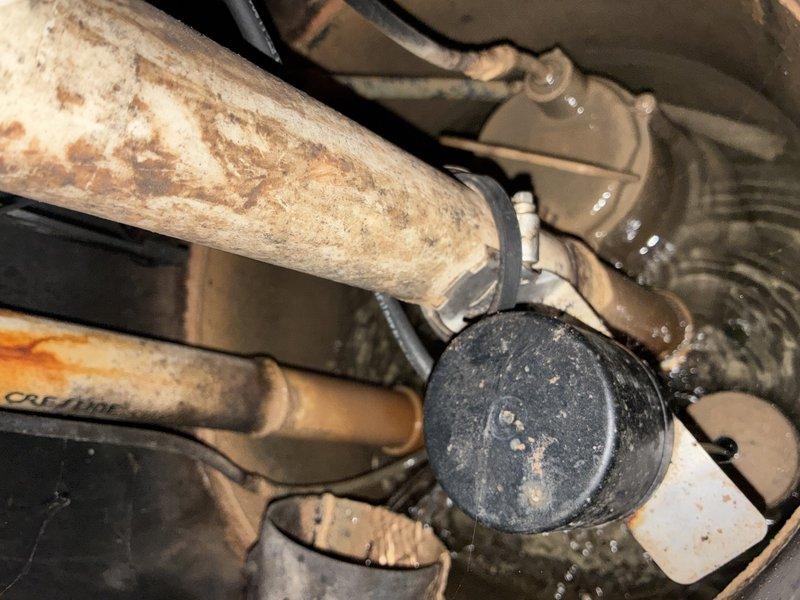 # Sump Pump Inspection

Performed comprehensive pre-winter sump pump inspection on an 8-year-old system. Documented existing conditions of submersible pump assembly, discharge piping, and basin components. Inspection revealed significant corrosion and rust deterioration on copper discharge pipes, with surface oxidation evident throughout the piping system. Verified pump housing integrity, float switch operation, and proper water level in concrete basin. Photographed all components including deteriorated pipe surfaces, pump assembly with circular cover plate and mounting bolts, flexible discharge hose, and basin conditions to document current system status prior to winter season.
