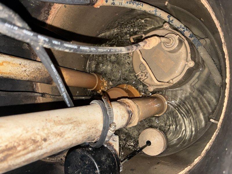 # Sump Pump Inspection

Performed comprehensive pre-winter sump pump inspection on an 8-year-old system. Documented existing conditions of submersible pump assembly, discharge piping, and basin components. Inspection revealed significant corrosion and rust deterioration on copper discharge pipes, with surface oxidation evident throughout the piping system. Verified pump housing integrity, float switch operation, and proper water level in concrete basin. Photographed all components including deteriorated pipe surfaces, pump assembly with circular cover plate and mounting bolts, flexible discharge hose, and basin conditions to document current system status prior to winter season.