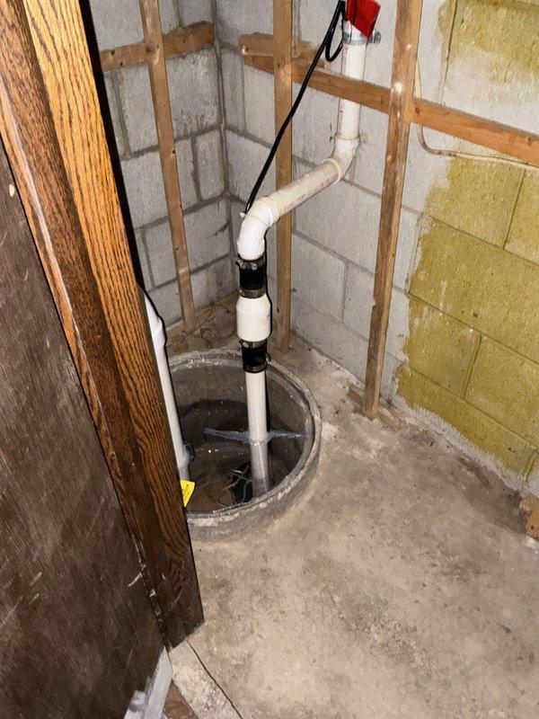 Completed comprehensive whole home plumbing inspection of residential property. Evaluated sump pump system in basement utility area, including PVC discharge piping, check valve operation, and pit condition. Inspected HVAC condensate drain line and connections, noting corrosion and mineral deposits on metal fittings that may require future attention to prevent potential leakage.