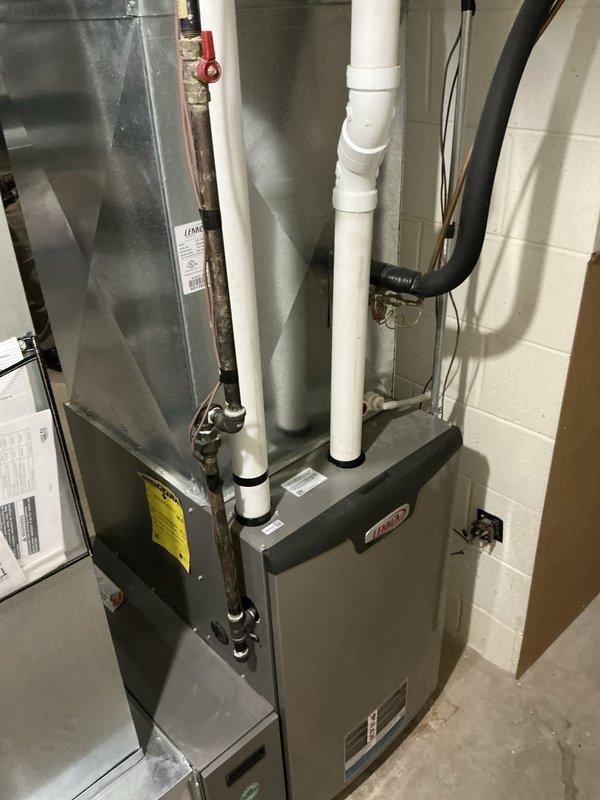 Responded to emergency furnace call and conducted comprehensive system evaluation in residential utility room. Assessed existing gray metal furnace unit with white PVC venting system and connected ductwork, documenting current equipment configuration including air handler, condensate drainage setup, and copper piping connections. Provided detailed replacement estimate for new furnace system installation to address heating system concerns.