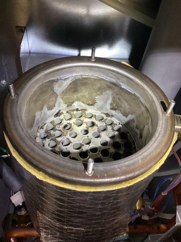 Completed high-efficiency boiler tune-up and identified significant mineral buildup and scaling on the heat exchanger components, indicating prolonged exposure to condensate. Observed active dripping from one of the system valves that requires attention to prevent further moisture-related deterioration and maintain optimal boiler performance.