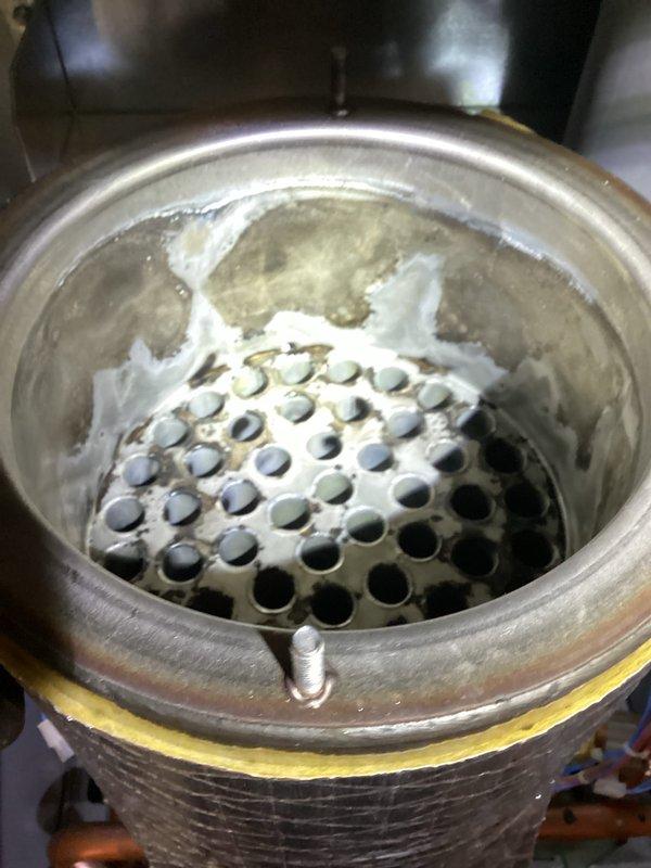 Completed high-efficiency boiler tune-up and identified significant mineral buildup and scaling on the heat exchanger components, indicating prolonged exposure to condensate. Observed active dripping from one of the system valves that requires attention to prevent further moisture-related deterioration and maintain optimal boiler performance.