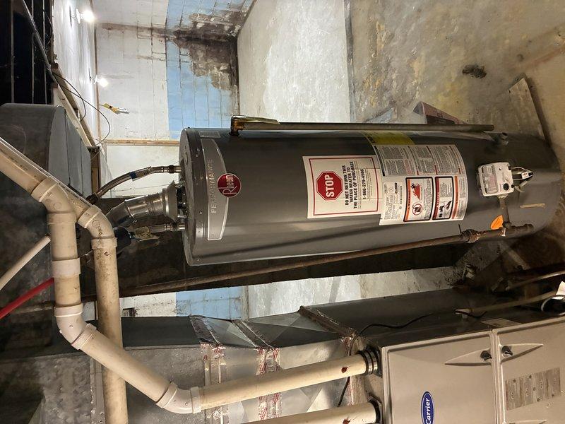 Conducted on-site assessment for water heater replacement in basement utility area. Evaluated existing water heater unit showing signs of age and potential moisture exposure issues, with surrounding area displaying significant water damage and deterioration to walls and ceiling surfaces. Customer requested new unit be elevated off ground level to prevent rust and corrosion from floor moisture contact. Documented current installation configuration including connected PVC piping, ductwork connections, and existing mechanical systems layout. Provided estimate for replacement water heater installation with elevated platform mounting to address moisture concerns and extend equipment lifespan.