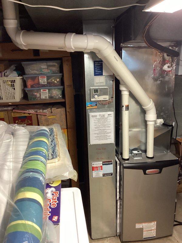 Completed full furnace installation in residential basement utility area with all required permits and licensed electrician coordination. New furnace unit installed with proper PVC venting system, ductwork connections, and digital thermostat control, with system pressure testing performed and verified at 1740 reading to ensure proper operation and safety compliance.