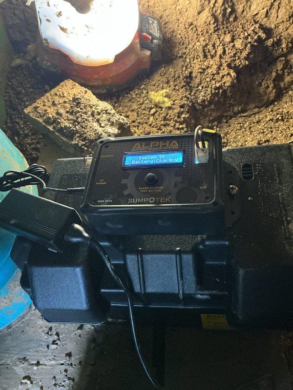 Responded to emergency service call for non-operational sump pump system with failed battery backup in crawl space. Upon arrival, found water had overflowed approximately 2 inches above crock level. Drained accumulated water from sump crock and assessed the Sumptek Alpha pump control system. Evaluated primary pump failure and battery backup malfunction that prevented automatic activation during power loss or primary pump failure. Inspected discharge piping, electrical connections, and float switch operation. Documented equipment condition and system configuration for repair recommendations.