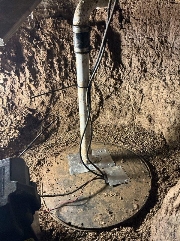 Responded to emergency service call for non-operational sump pump system with failed battery backup in crawl space. Upon arrival, found water had overflowed approximately 2 inches above crock level. Drained accumulated water from sump crock and assessed the Sumptek Alpha pump control system. Evaluated primary pump failure and battery backup malfunction that prevented automatic activation during power loss or primary pump failure. Inspected discharge piping, electrical connections, and float switch operation. Documented equipment condition and system configuration for repair recommendations.