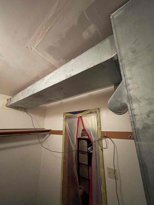 # HVAC Ductwork Installation

Completed comprehensive ductwork installation in an interior space undergoing renovation. Installed horizontal galvanized sheet metal trunk line with proper seaming and joints, along with vertical duct chase for distribution. Addressed heavily contaminated existing filter assembly that was obscured by significant dust and debris accumulation, requiring thorough cleaning and system preparation before integration with new ductwork. All components properly secured and sealed to ensure optimal airflow and system efficiency.
