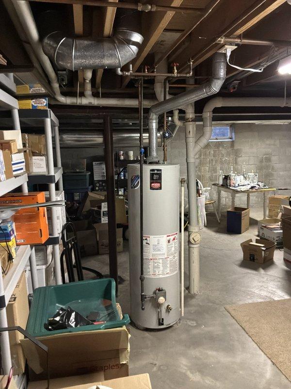 Conducted comprehensive water heater assessment in basement utility area and evaluated hot water distribution issue affecting kitchen sink. Inspected existing white cylindrical water heater unit, examined all supply and return piping connections, copper supply lines with shutoff valves, and verified proper venting configuration through galvanized ductwork. Documented current system condition including PVC drainage lines, pressure relief valve operation, and overall mechanical space layout to provide accurate replacement estimate and identify cause of inadequate hot water delivery to kitchen fixture.