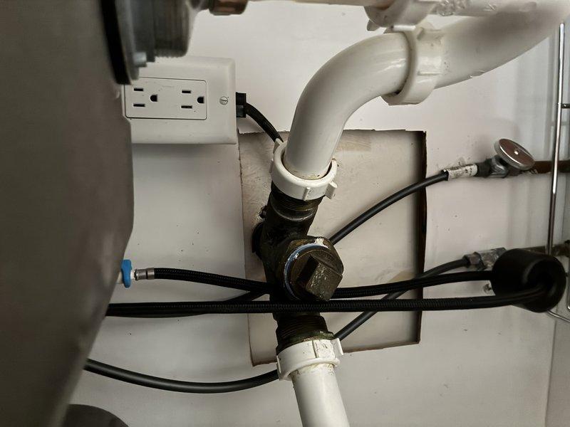 Responded to service call for clogged kitchen sink. Upon arrival, performed thorough inspection of the drain assembly and P-trap configuration beneath the sink. Examined all plumbing connections, including the white PVC P-trap, metal threaded fittings, and associated drainage components. Inspected supply lines, flexible hoses, and electrical connections in the under-sink area. Documented existing plumbing configuration with photographs showing brass fittings, pipe insulation, mounting hardware, and the overall condition of the drainage system. All components were assessed for proper installation, potential blockages, and signs of wear or deterioration.