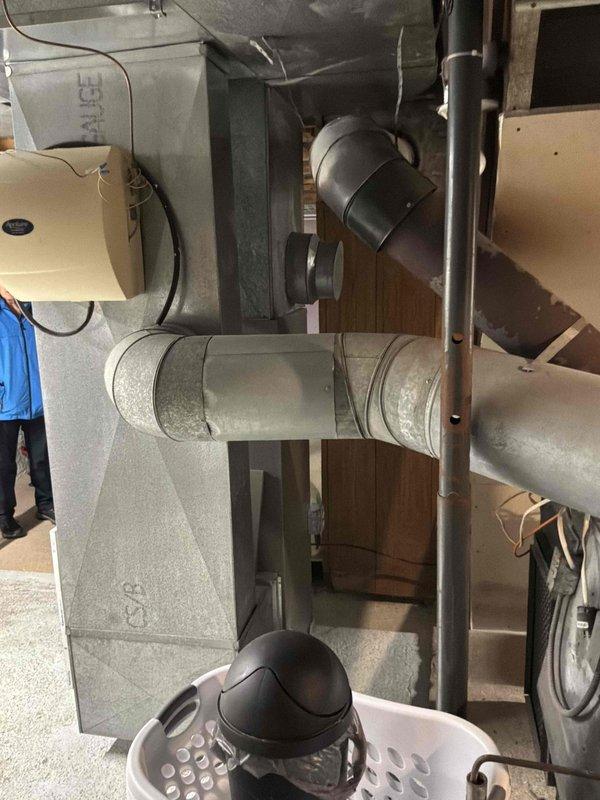 Conducted on-site assessment of existing fuel oil furnace system in basement of 1900 sq ft, 2-story single-family residence to provide replacement estimate. Current furnace unit approximately 18 years old, installed circa 2006, located in basement mechanical area. Inspected existing equipment configuration including air handler, ductwork connections, and associated HVAC components. Documented system layout with photographic evidence showing control module, wiring harness, galvanized ductwork with foil insulation, and mounted humidifier unit. Noted moisture condensation present on foam insulation surfaces within equipment compartment. Evaluated existing infrastructure including plumbing lines, gas connections, electrical service, and available space for replacement equipment installation. Provided comprehensive replacement estimate for new fuel oil furnace system suitable for heating requirements of 1900 sq ft residential structure.