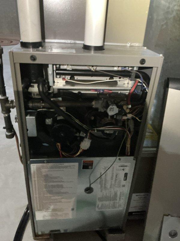 Completed furnace tune-up and inspection on residential HVAC system. Accessed air handler unit, verified all mechanical and electrical components operating within normal parameters, inspected blower motor assembly, checked wiring connections, and examined venting system including PVC intake and exhaust pipes. All safety labels present and system functioning properly upon completion.