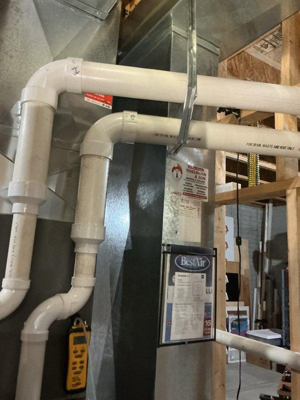 Completed furnace tune-up and inspection on residential HVAC system. Accessed air handler unit, verified all mechanical and electrical components operating within normal parameters, inspected blower motor assembly, checked wiring connections, and examined venting system including PVC intake and exhaust pipes. All safety labels present and system functioning properly upon completion.